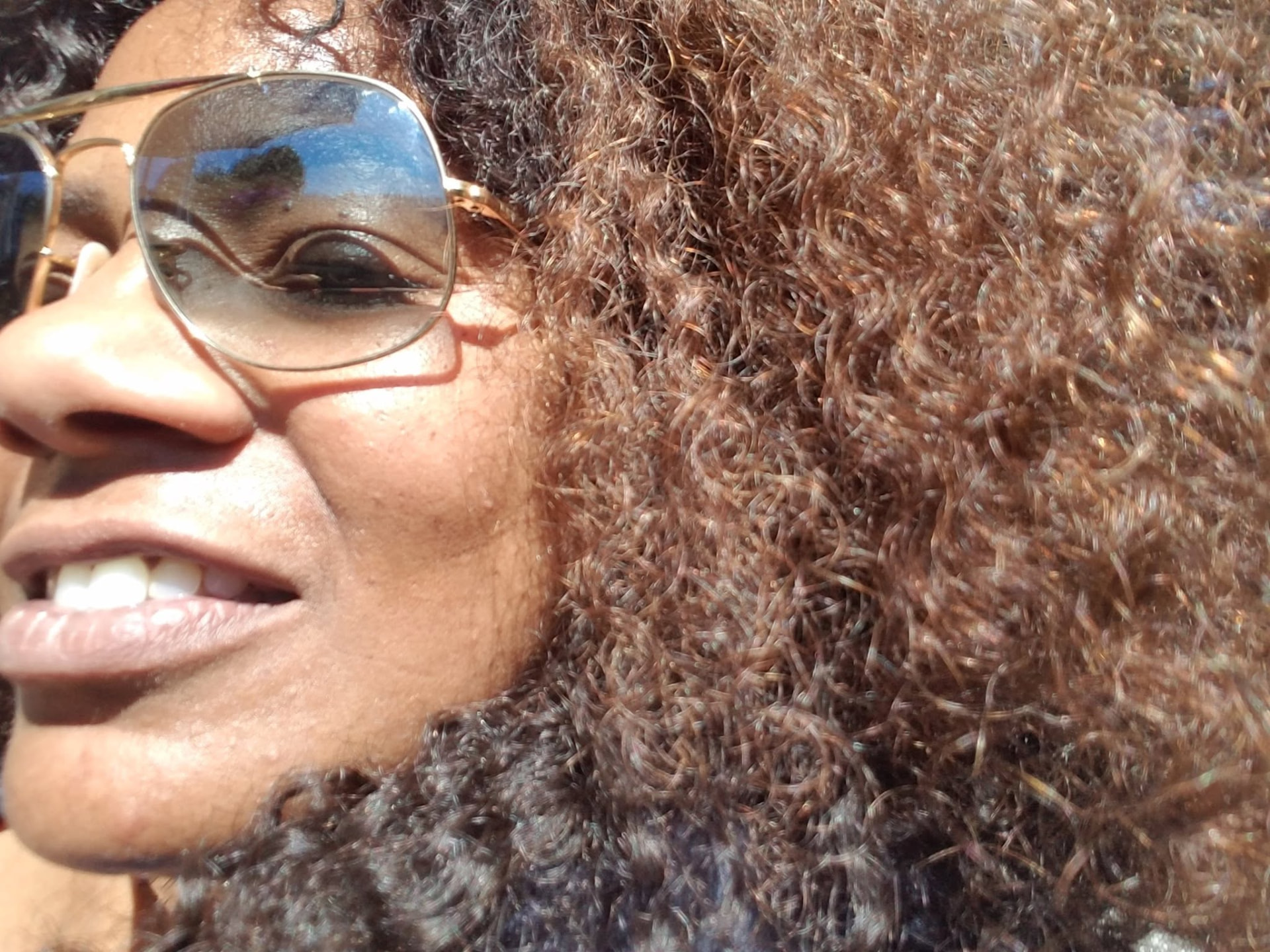 Close-up of Chilone outdoors in sunlight, sunglasses reflecting the sky